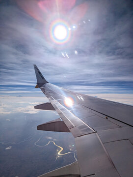 July 6, 2026, Montenegro, Aerial view from a Ryanair airplane wing with sunlight reflection over a winding river and clouds