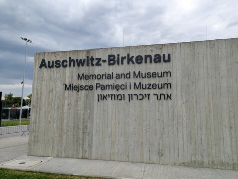July 7, 2026, Oswiecim, Poland, Auschwitz-Birkenau Memorial and Museum Signage Displayed in Multiple Languages with Surrounding Greenery