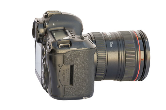 Close-up shot of a black digital single-lens reflex (DSLR) camera with a zoom lens. The camera showcases its design features against a clean white background, highlighting its technical craftsmanship.