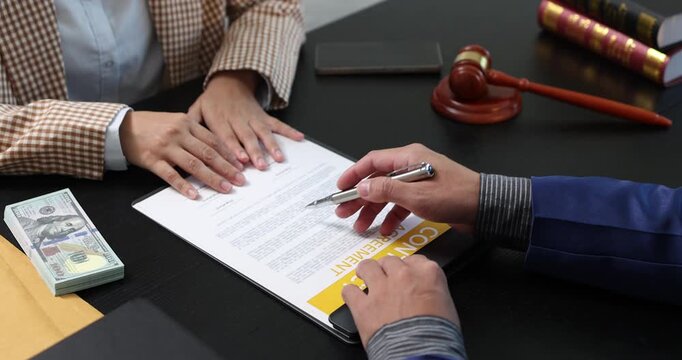 Legal consultation between a lawyer and a client, reviewing contract terms and discussing legal options to resolve disputes, protect rights, and make informed decisions.