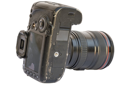 Black DSLR camera with lens displayed in a studio setting against a white background. High-angle view reveals LCD screen, buttons, and signs of wear.
