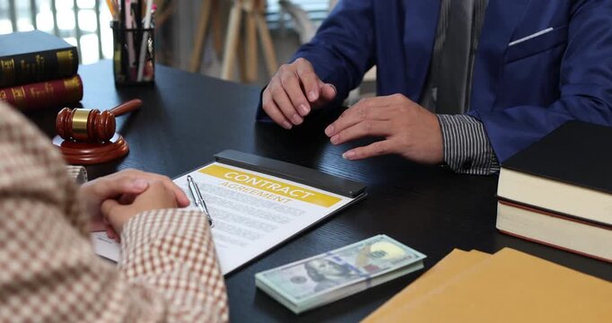 Legal consultation between a lawyer and a client, reviewing contract terms and discussing legal options to resolve disputes, protect rights, and make informed decisions.