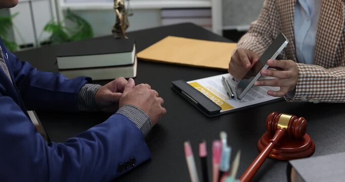 Legal consultation between a lawyer and a client, reviewing contract terms and discussing legal options to resolve disputes, protect rights, and make informed decisions.