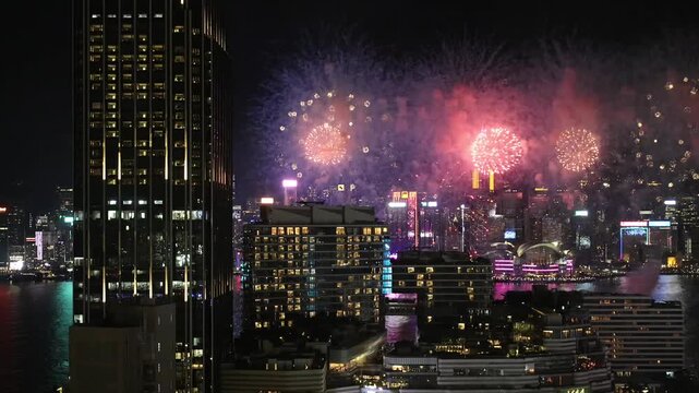 Fireworks over Hong Kong Victoria Harbour, medium telephoto view with skyline visible