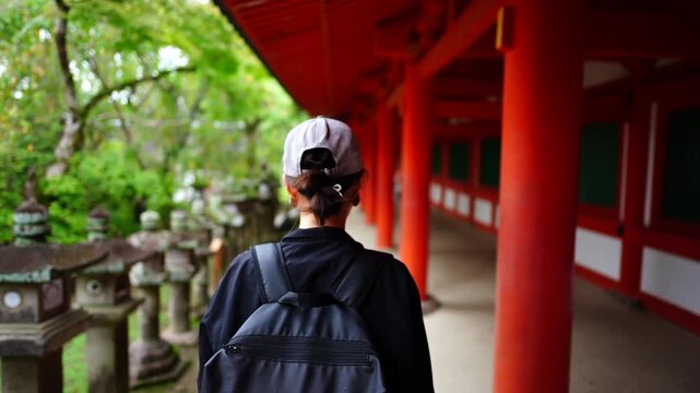 春日大社の朱色の回廊を歩く旅行者女性