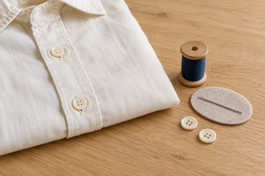 Cream shirt with thread spool needle and spare buttons