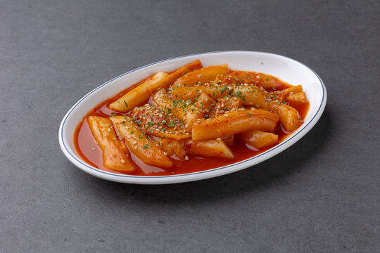 Spicy Korean street food tteokbokki rice cake on a white oval plate 타원형 접시에 먹음직스럽게 담긴 매콤한 한국식 떡볶이 45도 뷰