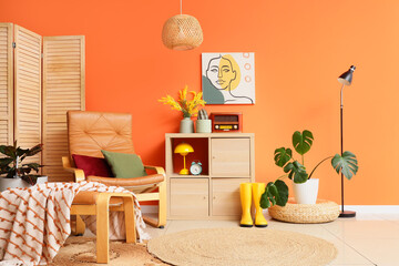 Interior design and home comfort, cozy living room with leather armchair and orange wall decor for modern lifestyle and residential living space © Pixel-Shot
