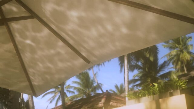 Shimmering reflected water light moving beneath a poolside parasol