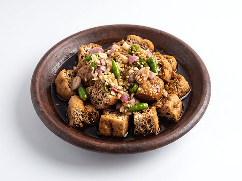 Tahu Gejrot, traditional Indonesian street food from Cirebon, fried tofu with sweet and spicy sauce in a clay mortar