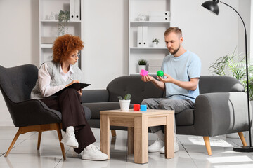 Psychotherapy and mental health counseling, therapist observing patient with sensory toys for...