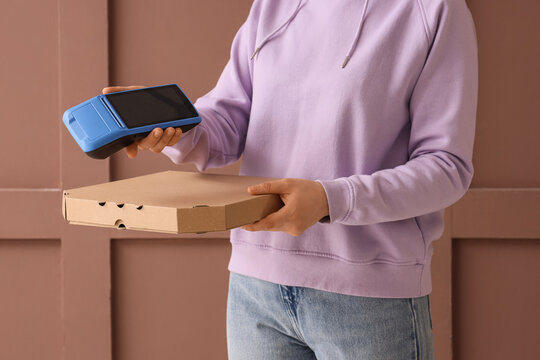 Contactless food delivery and payment, courier holding pizza box and mobile card terminal for secure transaction in modern service industry