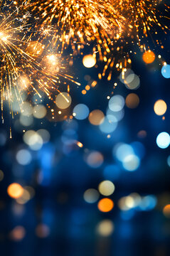 Bright golden fireworks display exploding against a dark blue night