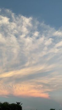 Clouds drifting in a sunset sky vertical video