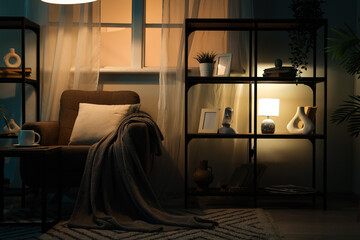 Cozy home interior at night relaxation and comfort with armchair warm lamp lighting and bookshelf in a quiet living room for evening rest © Pixel-Shot