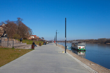 Spacerujący turyści na bulwarze, nad Wisłą, Toruń, Polska, Tourists strolling on the Vistula River boulevard, Toruń, Poland  © 123108 Aneta