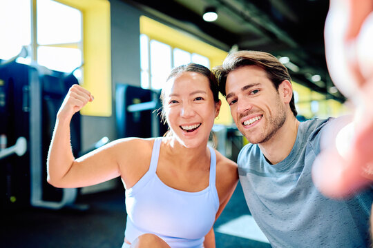 Enthusiastic man and woman smiling at camera, celebrating fitness and friendship after an energetic training session