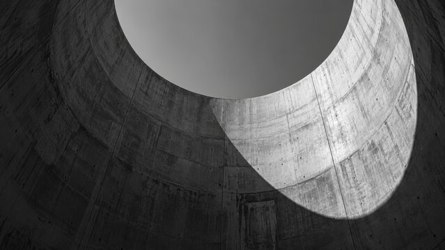 Modern architectural concrete interior with circular skylight and smooth surfaces