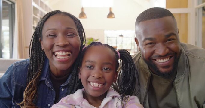 African American family taking selfies for memory as child holding phone, parents leaning, kissing
