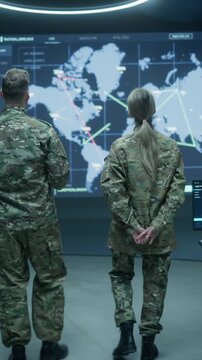 Vertical Screen. Military Base Monitoring Control Center With Army Surveillance Screens: Officers Brief Soldiers, Intelligence Analysts, Examining Satellite Maps, Tactical Data for Defense Operation