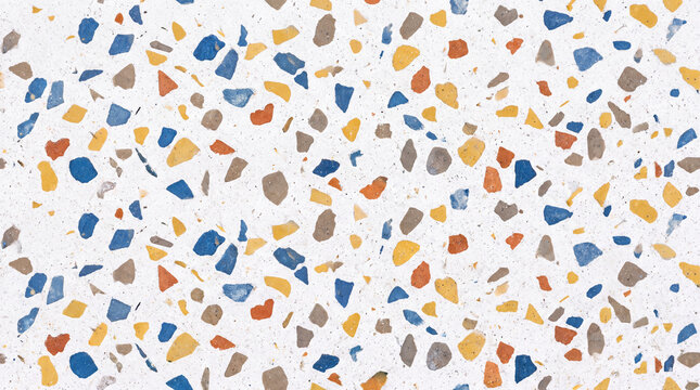 Colorful terrazzo texture background with blue, orange, yellow and gray stone chips on white surface