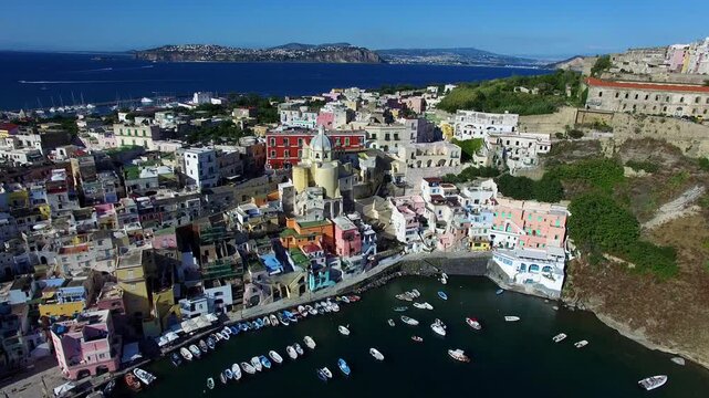 Colorful waterfront houses beneath a coastal cliff on Procida Italy
