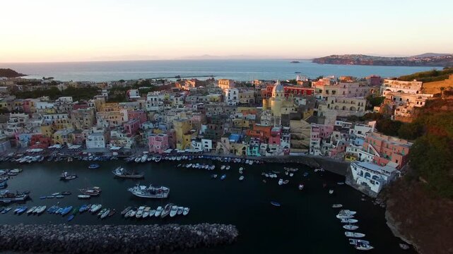 Evening aerial view of Procida waterfront houses and boats Italy