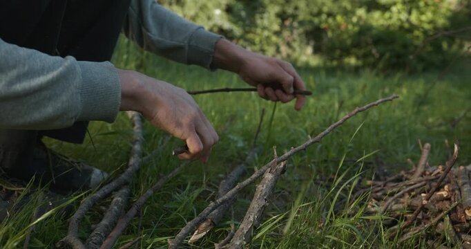 Close-up male hands break twigs, chop branches for firewood. 4K 10-b