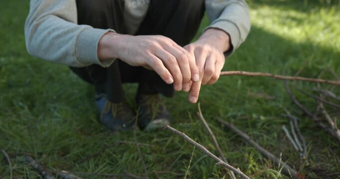 Close-up male hands break twigs, chop branches for firewood. 4K 10-b