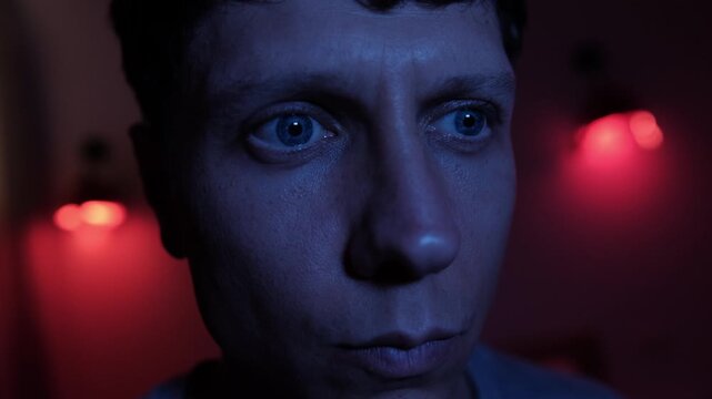 Suspicious man staring intensely in a dramatic close up, carefully observing his surroundings as if noticing something unusual, creating psychological tension, secrecy and an atmosphere of uncertainty