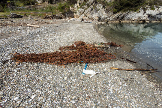 Discarded fishing nets and marine debris lying in the shallow, clear water at Tsoukalia beach on Alonissos in the Northern Sporades, Greece