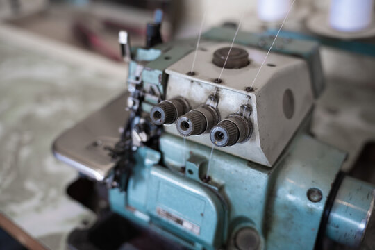  Vintage overlock machine close up representing a tailoring craft, fashion production, and textile industry concept.