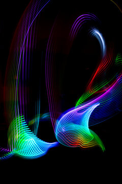 Colorful led light painting with swirling patterns on black background