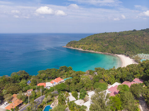 Aerial view of beautiful tropical white sand beach and turquoise sea bay with green forest mountain and coastal resort