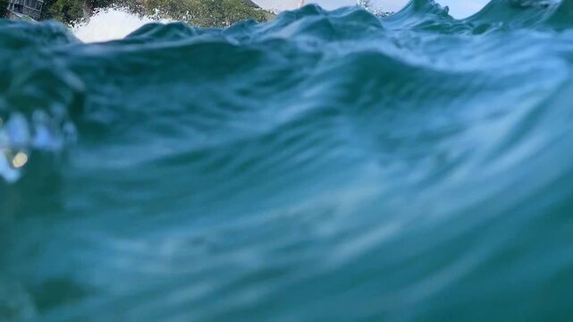 Close up view of clean ocean surfing wave barrel curling with white foam spray in tropical sea. Perfect background for surfing, water sports, and extreme adventure.