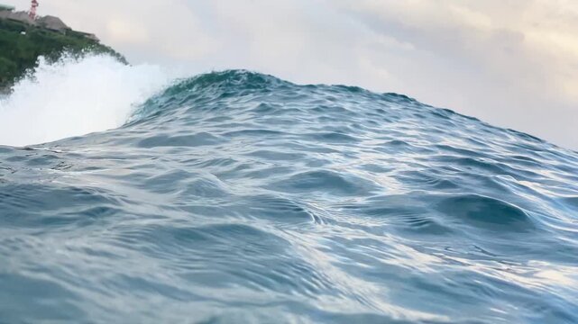 High speed action video capture of ocean surfing wave curling with crystal clear water and spray. High quality video stock background for sports and travel edits.