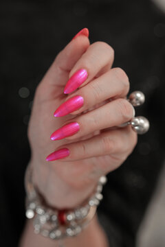 beautiful female hands with long nails and bright neon pink red nail polish