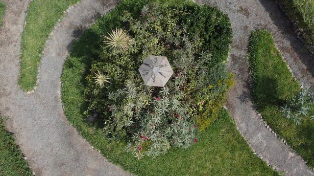 Aerial top down view of garden labyrinth with umbrella