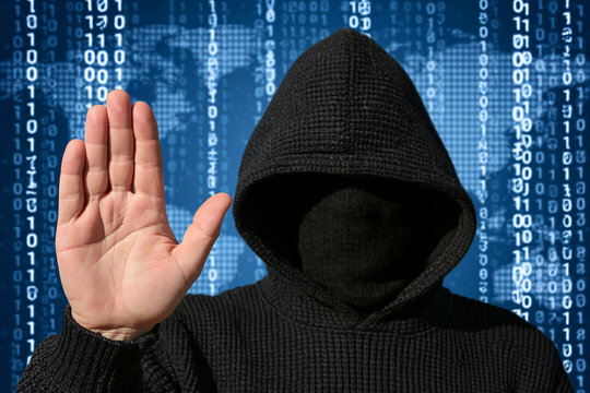 Hooded hacker figure raising hand against binary code