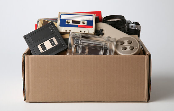 cardboard box filled with retro vintage electronics and
