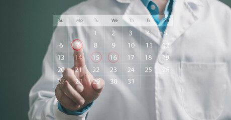 Medical appointment, scheduled consultations, health checkups, patient reminders, and preventive healthcare. Doctor highlighting dates on a digital calendar dashboard. © Krittamet