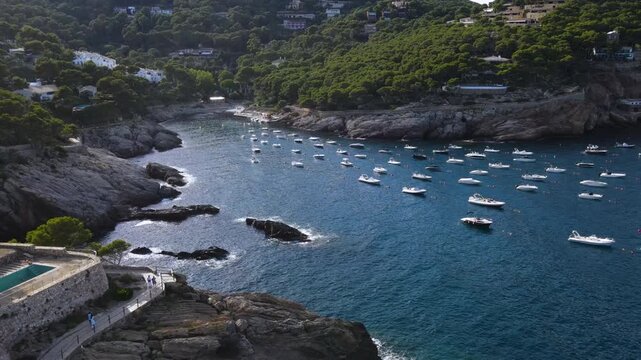Coastal path Cami de Ronda with an outdoor pool on a rocky shore beside the bay. Aerial view of Cala d'Aiguafreda, Begur, Costa Brava, Girona, Catalonia, Spain