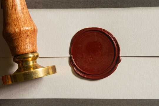 Red Wax Seal Stamp on Envelope with Vintage Metal Stamping Tool for Classic Letter and Invitation Detail