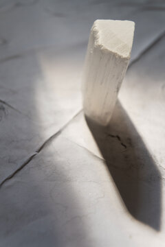 Selenite Rock Mineral Crystal on Grunge White Background with Natural Sunlight and Soft Shadow