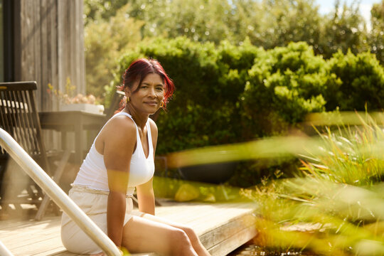 Woman sits on a wooden deck