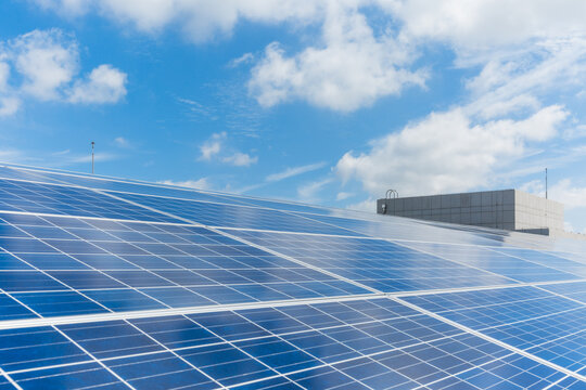 Photovoltaic Solar Panels Installed on Rooftop Under Blue Sky