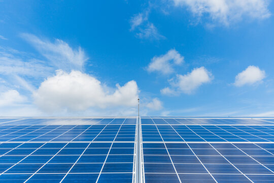 Symmetrical Solar Panel Array Under Bright Cloudy Sky