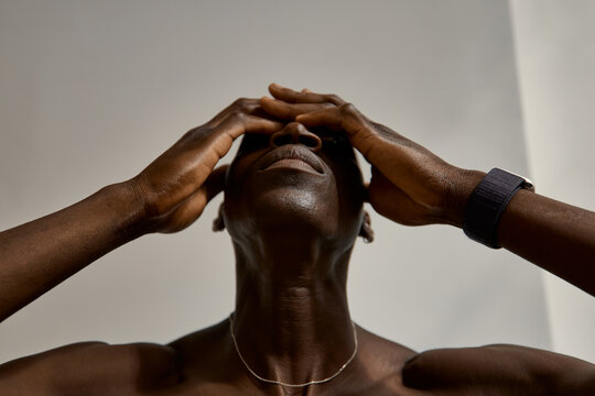 Person holding head while standing indoors at home