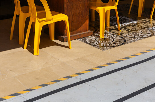 Yellow Plastic Chairs and Patterned Tile Floor in Modern Cafe
