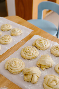 Raw cinnamon rolls on kitchen paper ready for the minimalist oven.